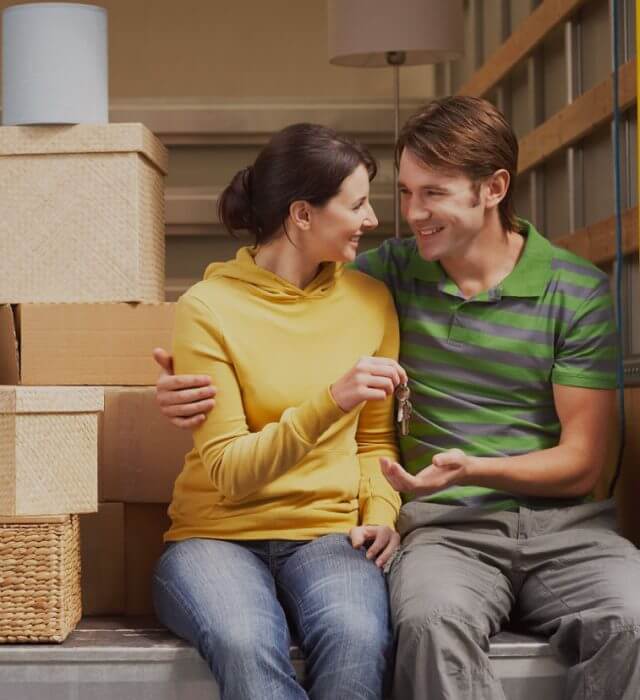 A happy couple sitting in a removals van after having had help to sell their home