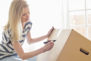 A woman labelling a box during her assisted house move