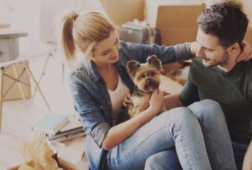 A happy couple petting their small dog