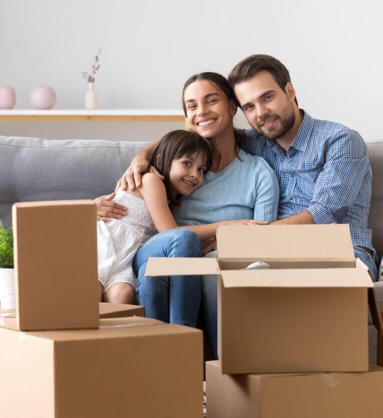 A happy couple recline with their daughter after moving into a part exchange house A happy couple recline with their daughter after moving into a part exchange house